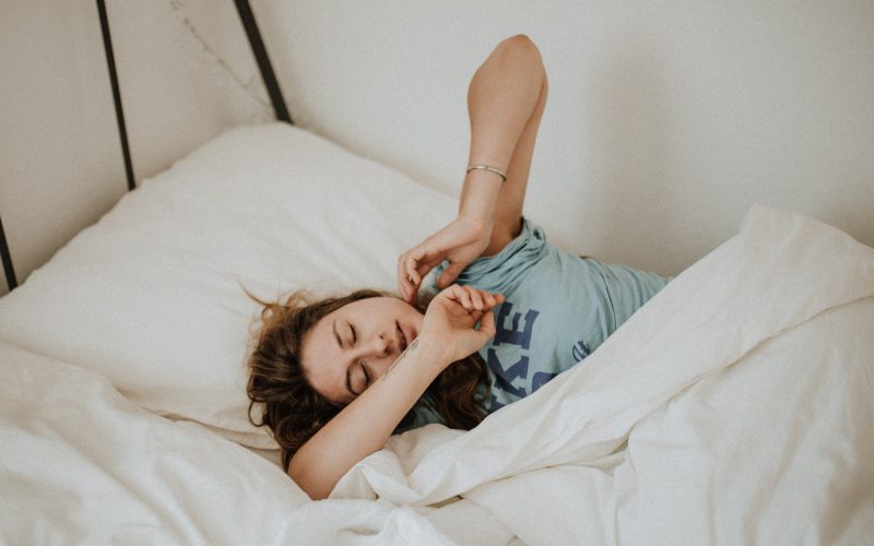 Jeune femme qui s'étire en se réveillant après une bonne nuit de sommeil