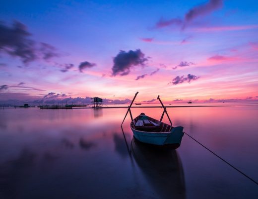 barque au milieu de l'eau et couché de soleil